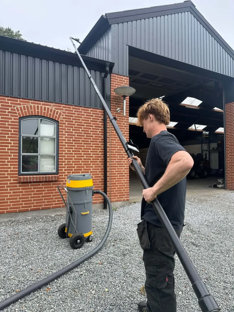 Rensning af tagrender på landejendom med sugeudstyr